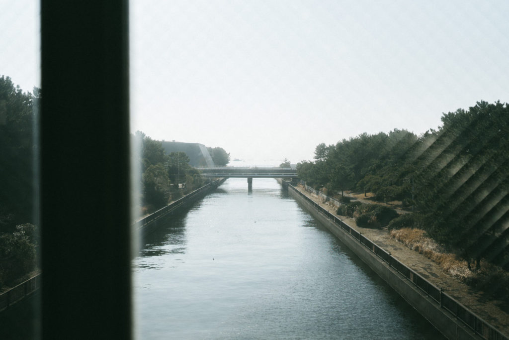 賑やかな渡り廊下とは対照的な穏やかな川と東京湾の船